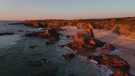 Vista-Aérea-De-Una-Playa-Rodeada-De-Impresionantes-Formaciones-Rocosas-En-Algarve,-Portugal.