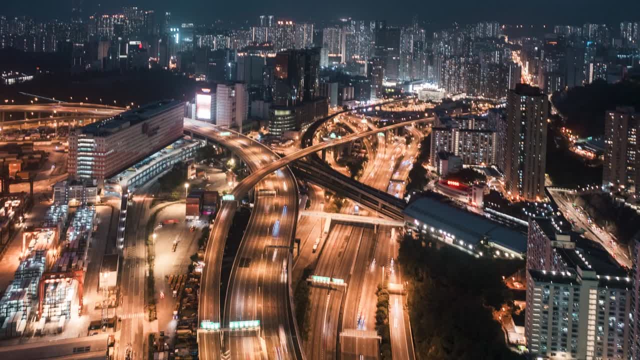 Highway cloverleaf interchange intersection (junction) with ramps, heavy traffic, aerial hyperlapse. A cloverleaf typical four-way interchange. Bird view of traffic at night at Lai King, Hong Kong