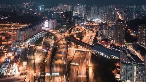 highway cloverleaf interchange intersection (junction) with ramps, heavy traffic, aerial hyperlapse. a cloverleaf typical four-way interchange. bird view of traffic at night at lai king, hong kong
