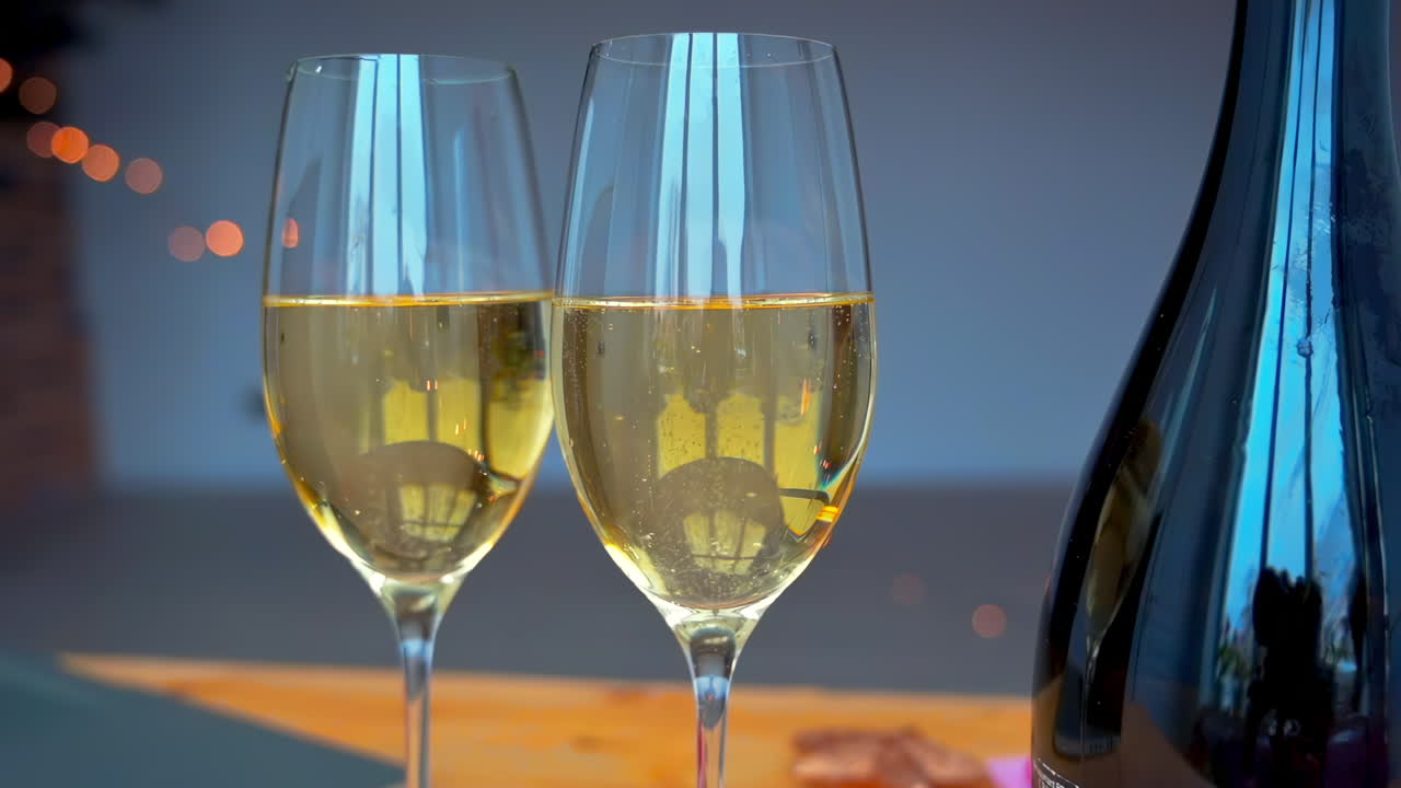 Two glasses of sparkling wine are elegantly displayed next to a bottle, creating a festive atmosphere perfect for a cozy evening celebration with friends or family