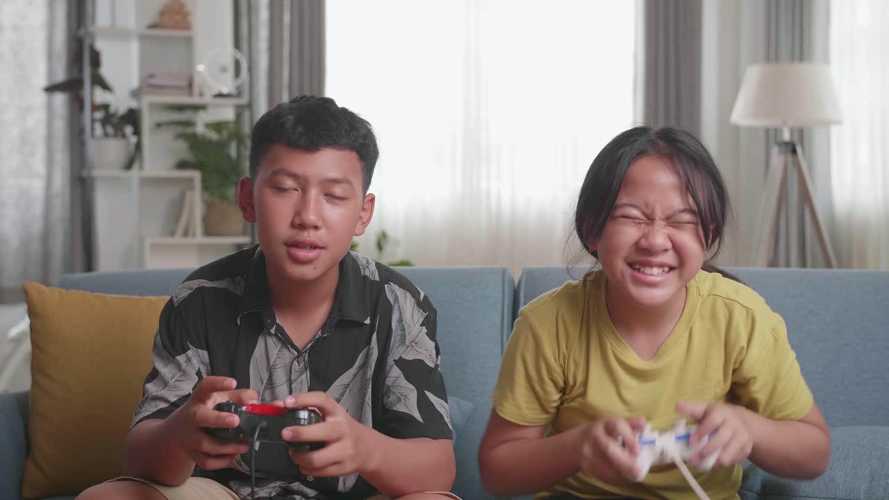 Asian Children With Joystick Game Play Video Game On Tv, Girl Celebrating Victory And Boy Disappointed