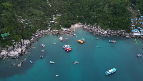 Aerial-top-down-shot-of-Ao-Hin-Wong-Beach-with-parking-boats-on-clear-water-with-rocky-coastline-and-jungle-on-Koh-Tao,-Thailand