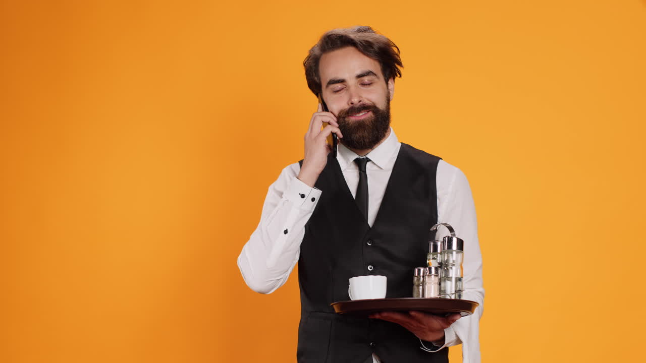 joven mayordomo respondiendo una llamada telefónica