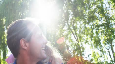 padre dá piggyback a su hija en el parque