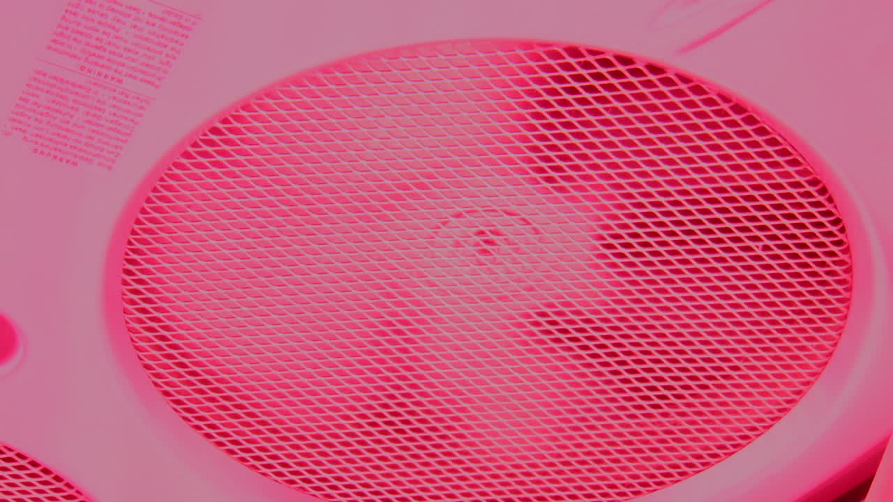 ventilador extractor girando dentro de la máquina de bronceado con luz roja rosa