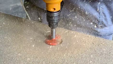 carpenter making a hole in a wooden piece