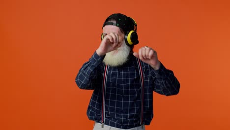 elderly old man listening music on headphones dancing disco fooling having fun gesticulating hands