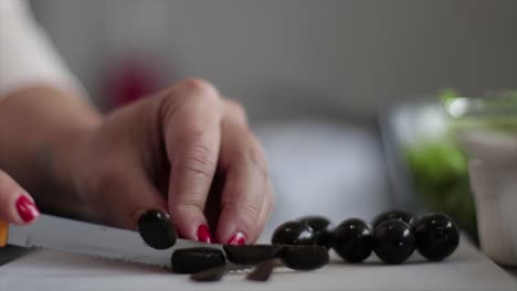 chopping olives on a chopping board in a kitchen