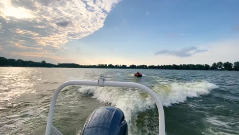 person tubing behind a boat during the summer