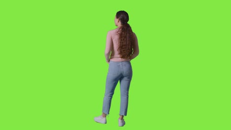 full length rear view studio shot of woman looking all around frame against green screen in vr environment 1