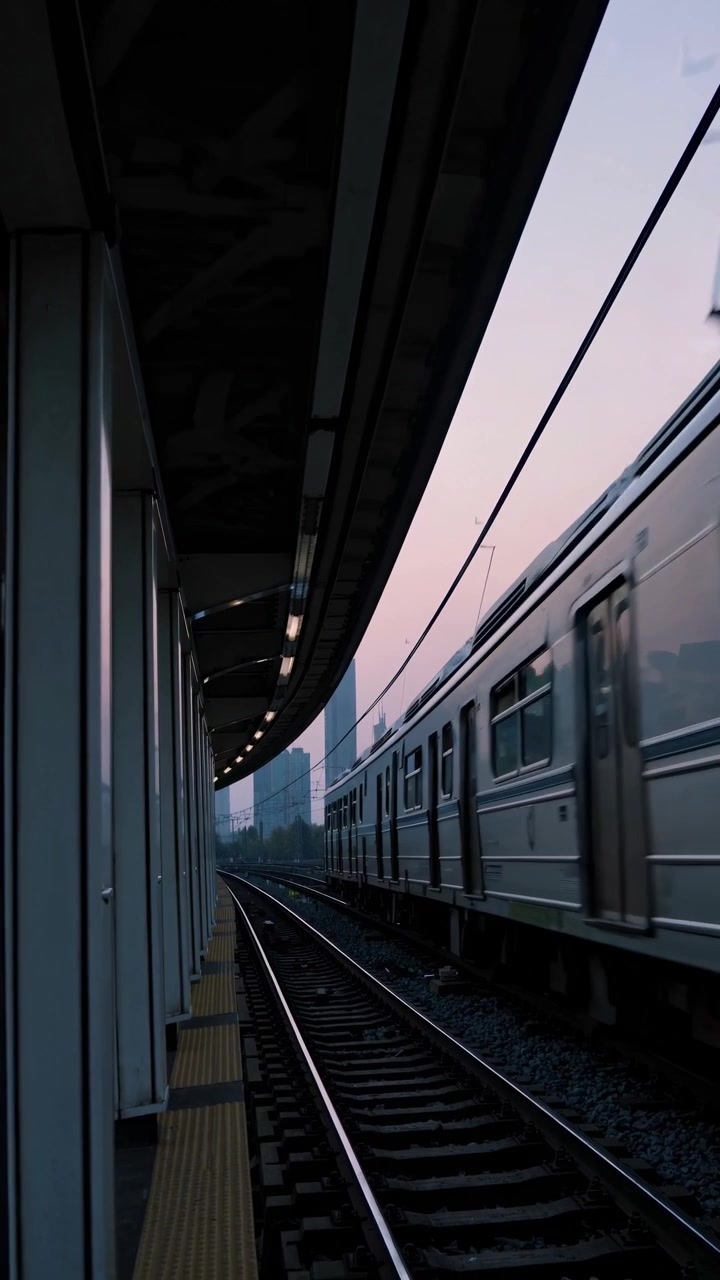 Subway Train Moving Past Station Platform at Twilight