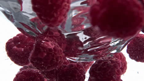 clear raspberry beverage funnel inside glassware closeup. cold cocktail spinning