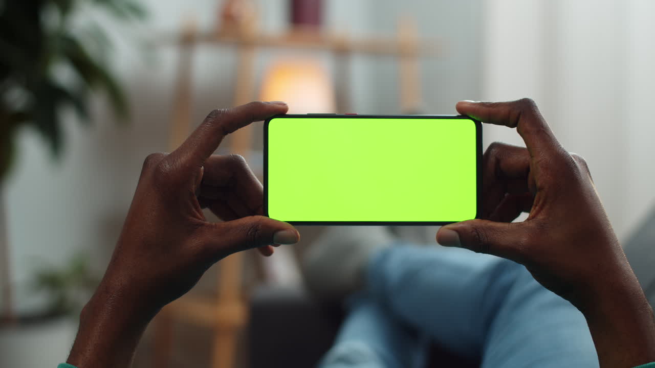 Person holding phone with green screen