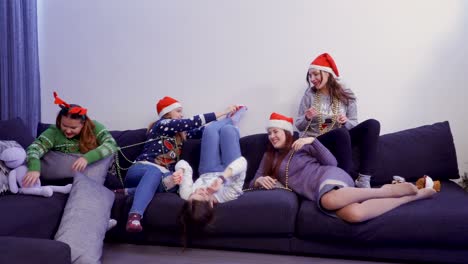 five girls chilling on the sofa and play with each other