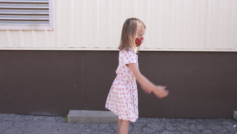 A-little-girl-in-a-mask-just-wants-a-hug-at-school,-but-no-one-is-allowed