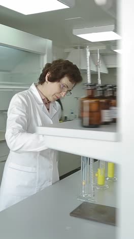 scientist in labcoat doing experiments in lab