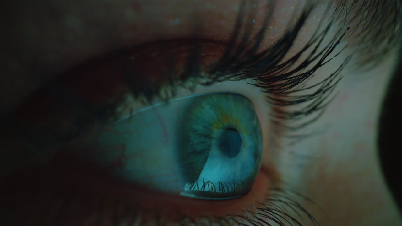 макро глаз смотрит на экран компьютера ночью просматривает интернет с отражением в глазу