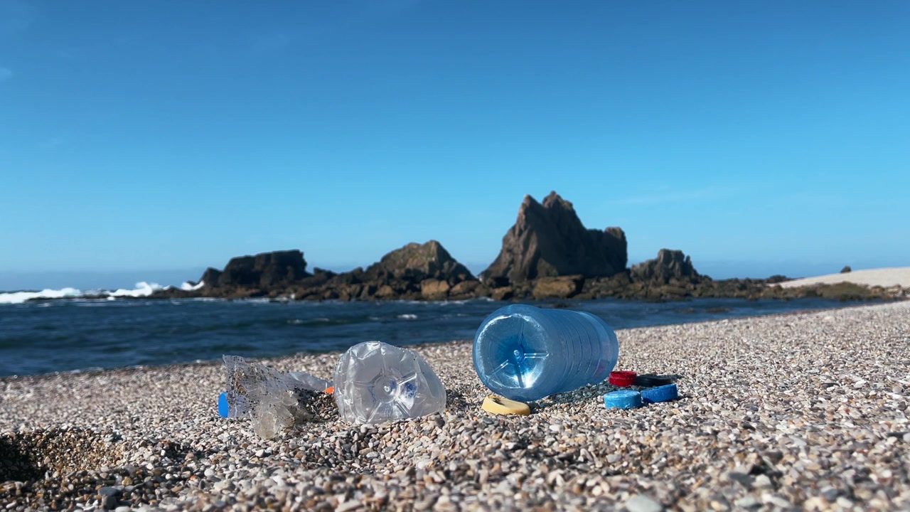 Bottiglie e tappi di plastica che inquinano una spiaggia marittima