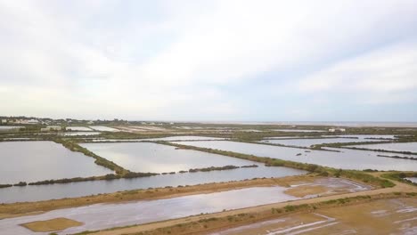 4k aerial footage wide view of coastal area over fuseta in the south of portugal with mudflats filled with water