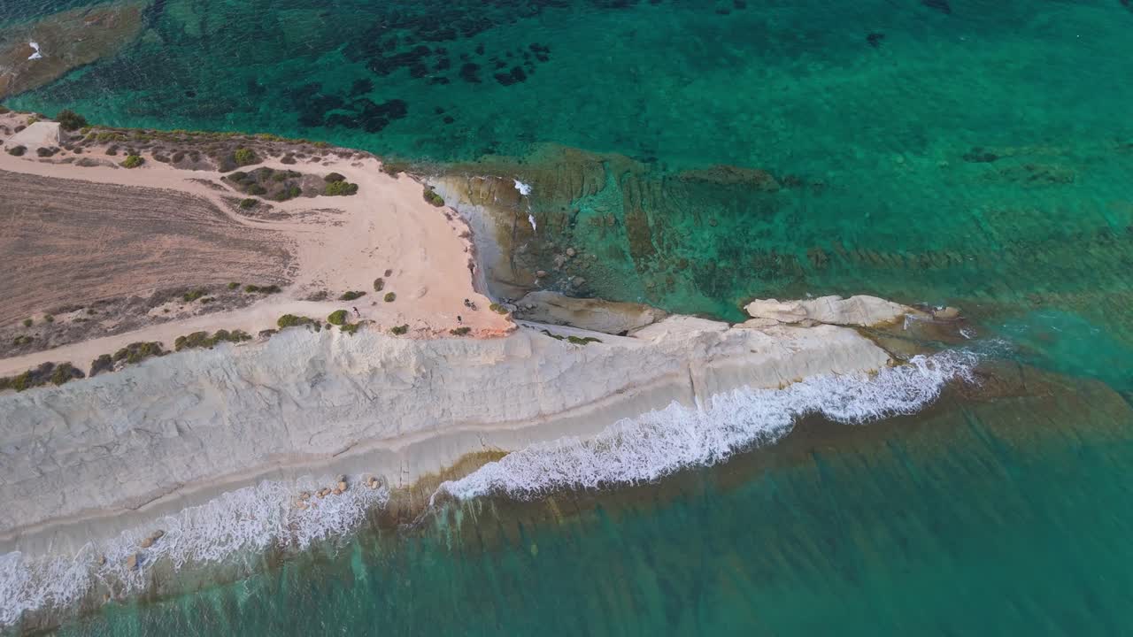 Circular aerial view of the Mediterranean Sea washes the sharp cliffs of the Munxar Path in Malta