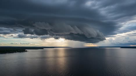 dramatic storm clouds and rain over a lake at sunset