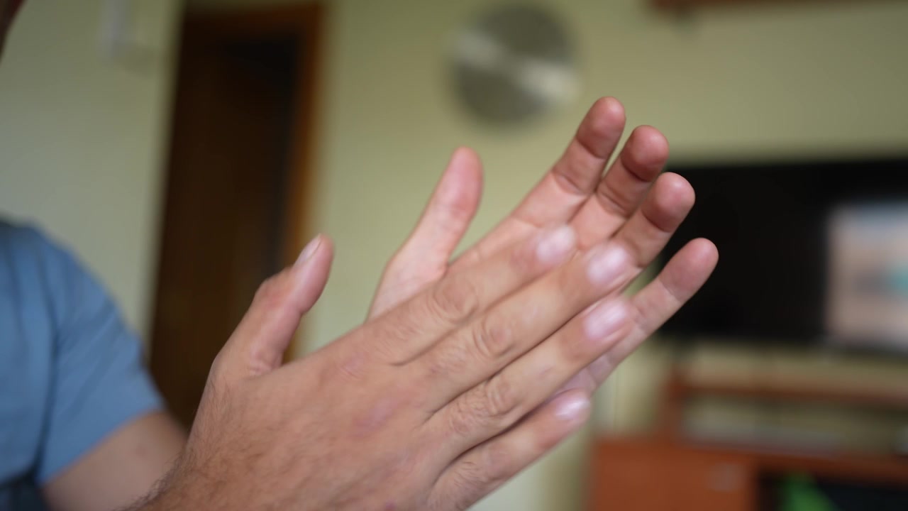 Um close-up de mãos que estão batendo palmas ou esfregando-se alegremente em uma celebração dinâmica