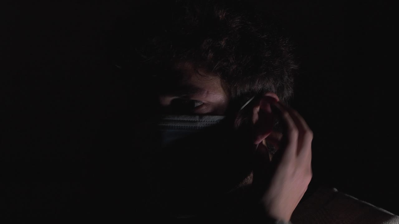 hombre con poca luz con máscara protectora contra el virus covid-19