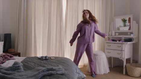 mujer feliz bailando en el dormitorio disfrutando de la mañana de fin de semana divirtiéndose celebrando un estilo de vida despreocupado usando pijama en casa