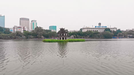 hoan kiem lake and modern buildings in the background in hanoi, vietnam
