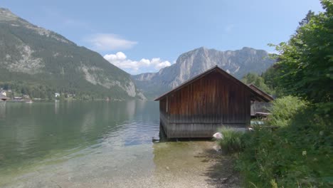 alps, lake scenery with wooden boat hangar and picturesque mountain range