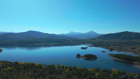 temprano otoño colores amarillos árboles de aspera lago dillon colorado aéreo cinematográfico dron vista matutina frisco breckenridge silverthorne rango de diez millas tranquilo agua reflectante movimiento hacia adelante amplio