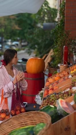 woman shopping for fruits at an outdoor market