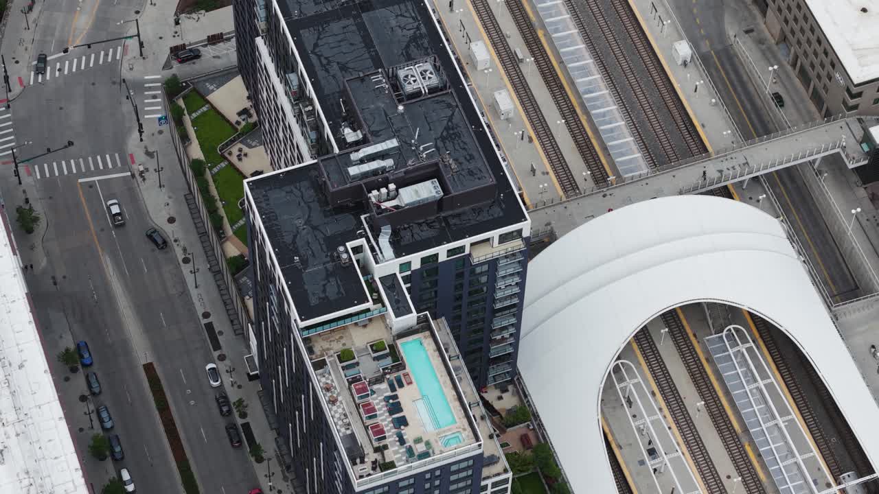 Telezoom aerial view tracking a train arriving to the railway station of Denver