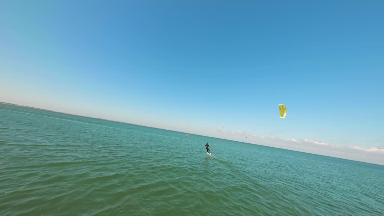 Kitesurfer glides smoothly across the surface of the open sea beneath a magical celestial vault