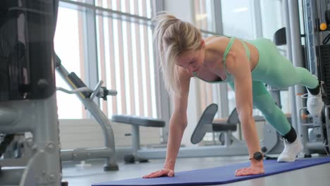 a woman is performing push ups on a yoga mat inside a gym facility a woman is performing push ups on a bright yoga mat located within a busy gym showcasing her dedication to physical fitness and wellbeing