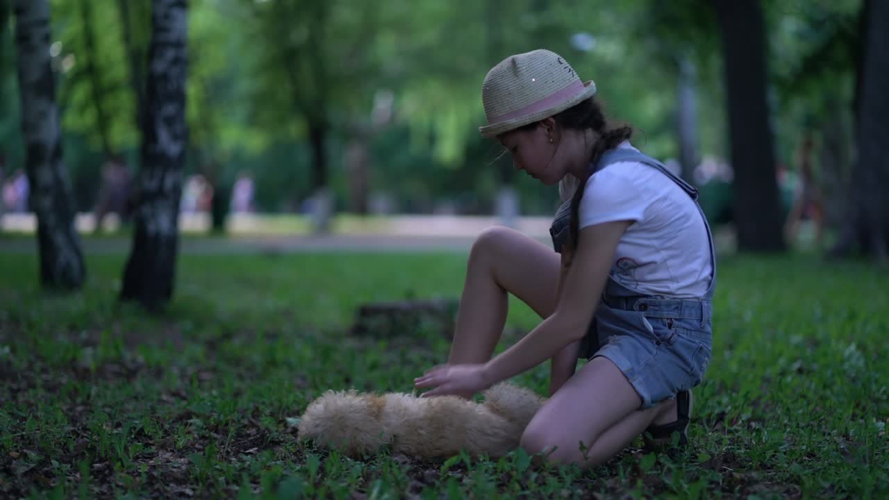 어린이 소녀가 야외에서 장난감 푸들 개와 놀고 있습니다.