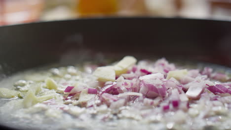 frying garlic and red onion in pan