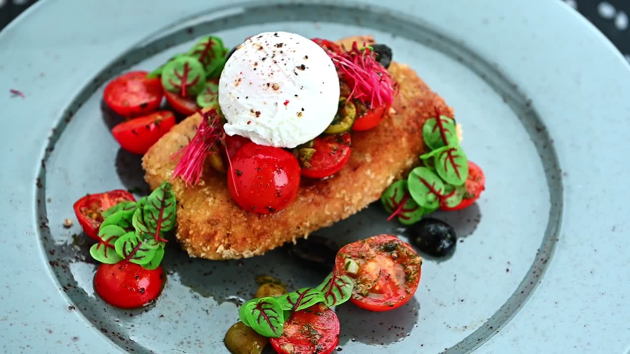 Delicious dish with crispy breading served with fresh vegetables and sauce