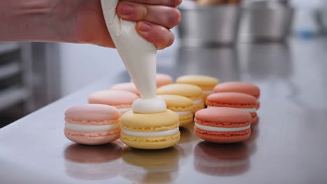 piping cream onto macarons