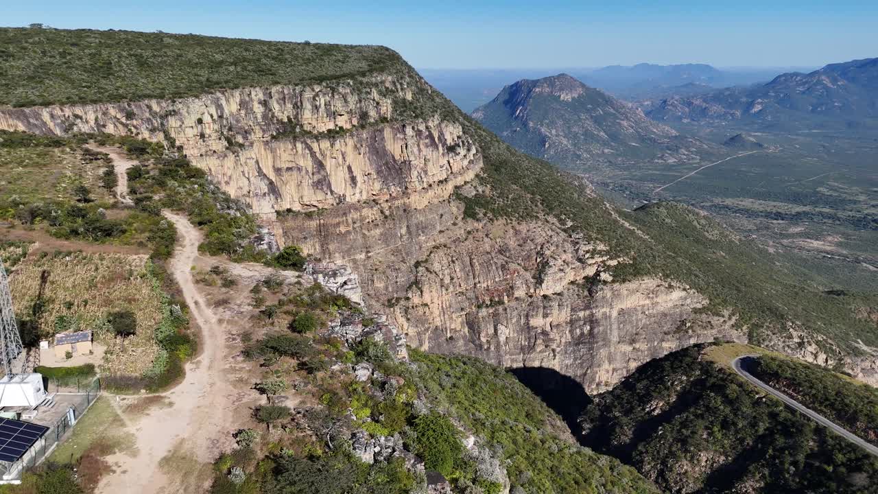 Aerial view of Tundavala Gap near Lubango, Angola, showing dramatic cliffs and vast green valleys under clear blue sky