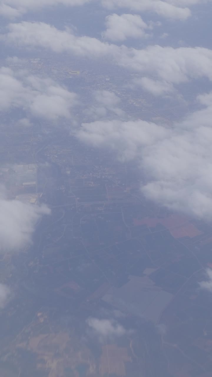 Cloudy aerial view showing fluffy clouds and land below with serene mood