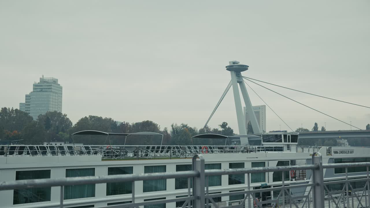 Moderno Puente OVNI sobre el río Danubio en Bratislava con un crucero atracado.