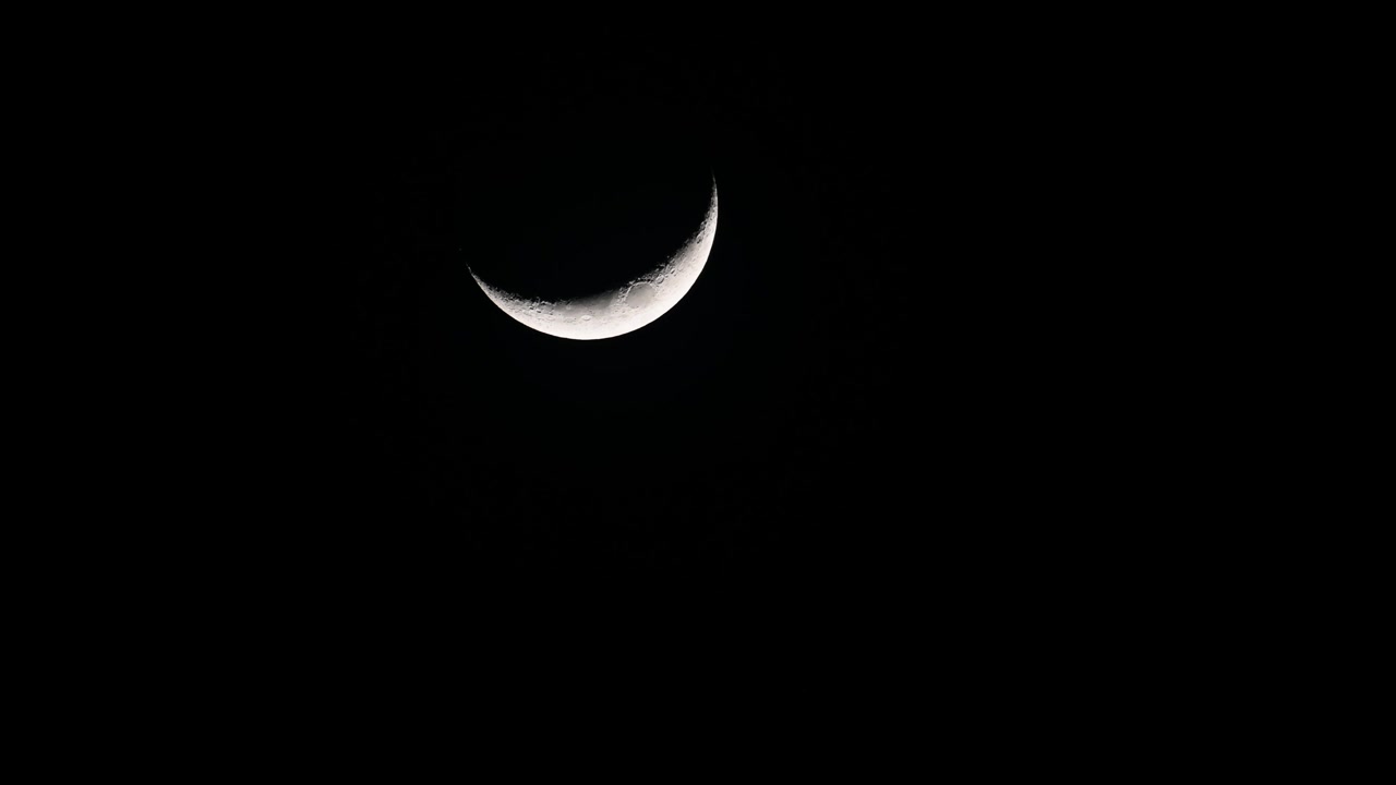 Zunehmender Sichelmond, 4K-Filmmaterial, in der Bildmitte zu sehen, wie er mitten in der Nacht langsam untergeht.