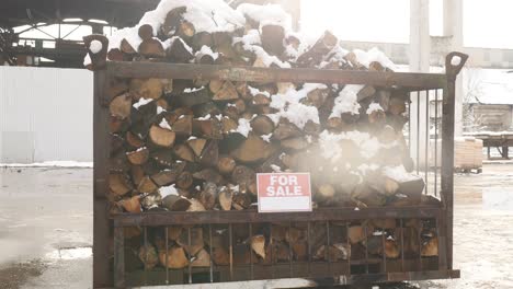 the stacked firewood under the snow "for sale