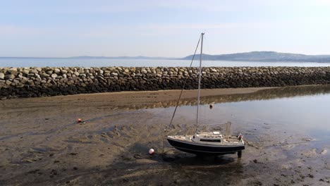 aerial view boats in shimmering low tide sunny warm rhos on sea seaside sand beach marina low dolly right