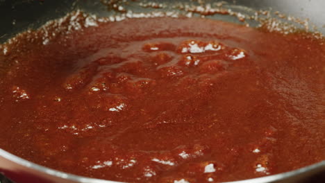 cooking a red sauce in a pan