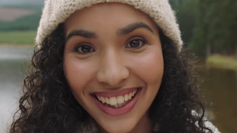 close up portrait beautiful mixed race woman laughing looking happy wearing beanie enjoying cold winter outdoors in nature by lake real people 4k