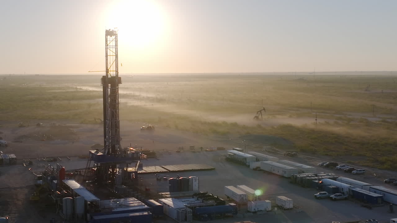 dron aéreo al amanecer en un pozo de petróleo rural de texas y sitio de perforación de gas - puesta de sol con jack de bomba