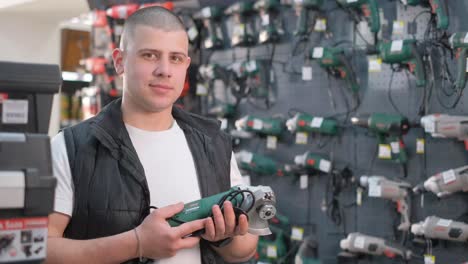 man holding a grinder in a hardware store
