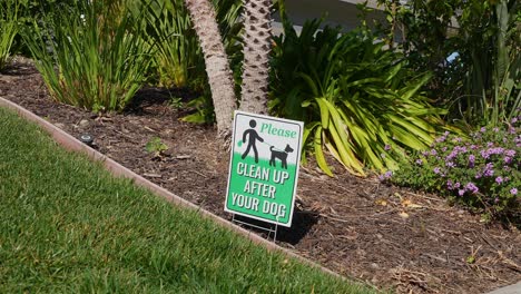 dog poop sign in residential lawn and flower bed